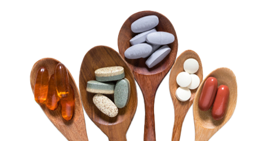 Photograph of 4 different wooden spoons with different tablets and capsules in them