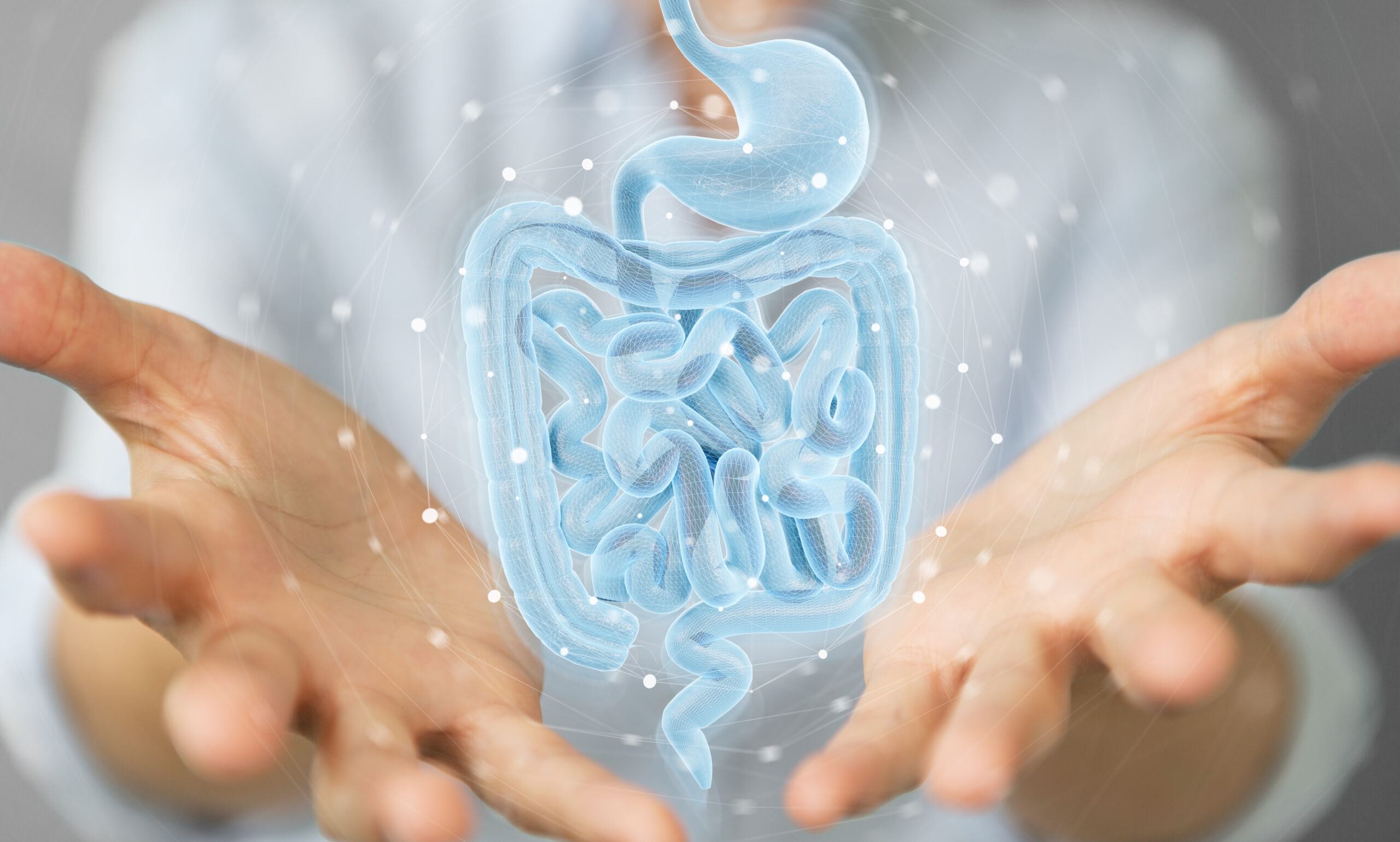 Photograph of a medical professional opening their hand and a computer generated technical image of a gastrointestinal tract diagram is being revealed.